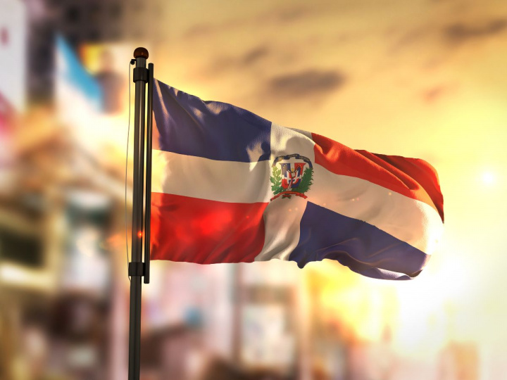 Bandera de República Dominicana contra ciudad borrosa