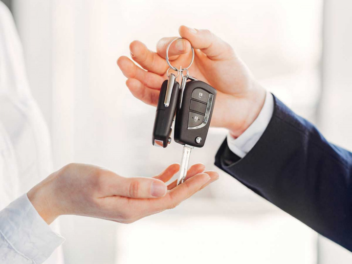 Una persona recibe las llaves de su auto nuevo.
