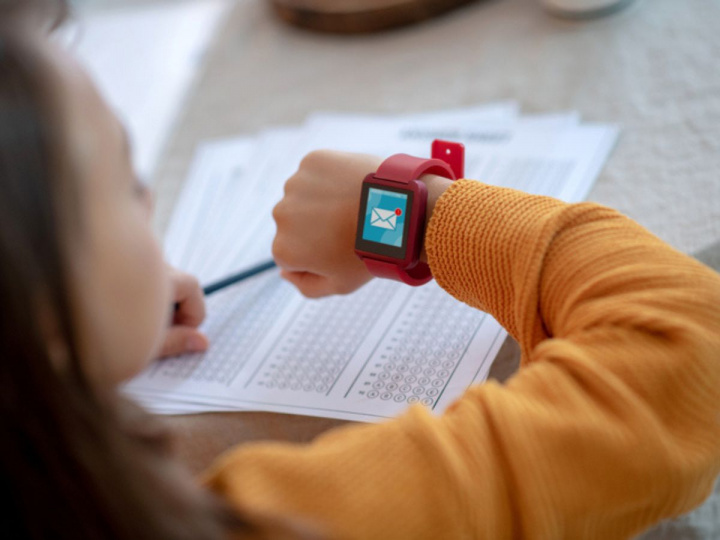 Niña mirando notificación en reloj inteligente para niños porque sabe cuáles son sus ventajas 