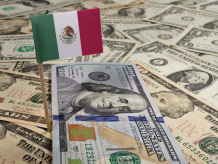 Billetes de dólares americanos y bandera de México