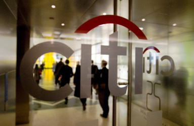 El logotipo de Citigroup en una puerta de cristal y personas en la parte interior del lugar. 