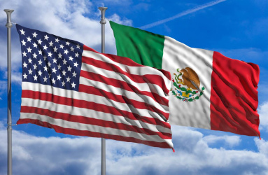 Bandera de Estados Unidos y México ondeando en el cielo azul 
