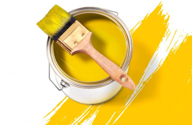 Brocha sobre bote de pintura color amarilla 