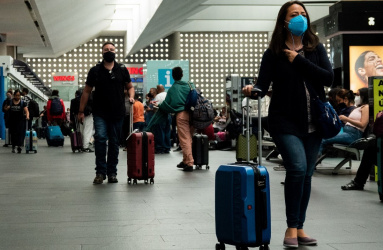 Personas caminando con maletas en la Terminal del Aeropuerto Internacional de la ciudad de México (AICM). 