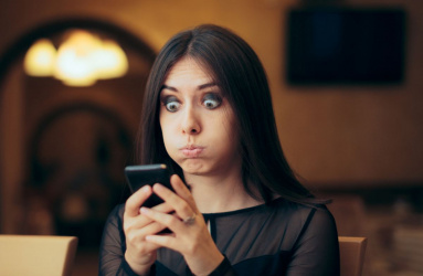 mujer sorprendida viendo teléfono celular