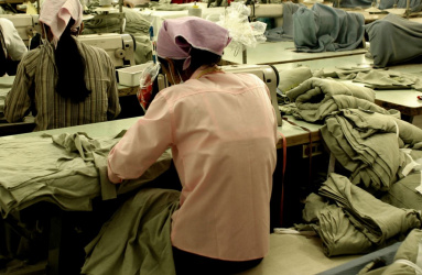 Mujer sentada trabajando en maquina de coser