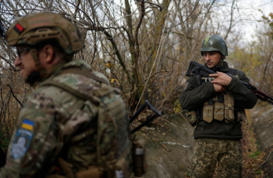 Dos soldados de Ucrania portan su uniforme y armas al estar vigilando. 