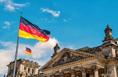 Edificio de Alemania con dos banderas y el cielo azul de fondo. 