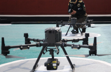 dron sobre plataforma de despegue con policia de fondo 