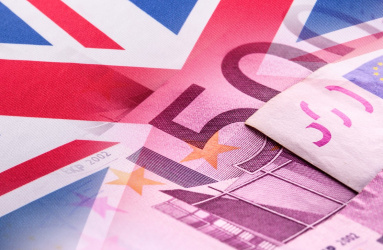 La bandera de Reino Unido con unos billetes al costado. 