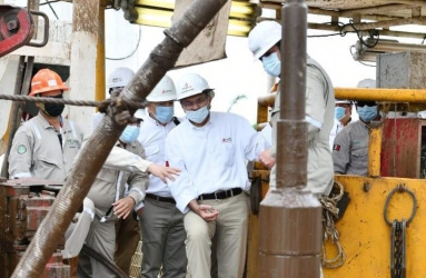 Varios trabajadores de Pemex observan un pozo petrolero. 