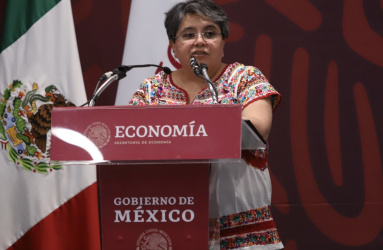 Raquel Buenrostro, titular de la Secretaría de Economía, hablando frente a un micrófono. 