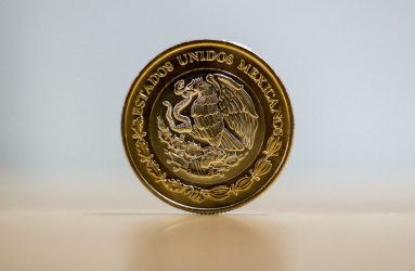 Una moneda de diez pesos mexicanos en color dorado con el escudo del águila. 