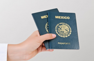 Mano sostiene dos pasaportes mexicanos 