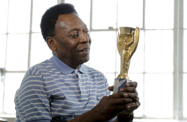 Pelé sosteniendo un trofeo