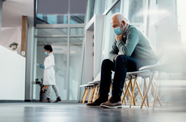 Un hombre sentado en la sala de espera de un hospital.
