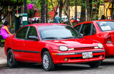 Auto neon dodge rojo estacionado en una calle de México,