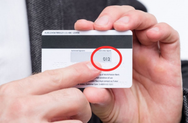 Persona señalando código CVV de tarjeta de crédito