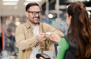 Hombre sonriendo entregando tarjeta de crédito 