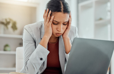 Mujer estresada frente a su computadora 